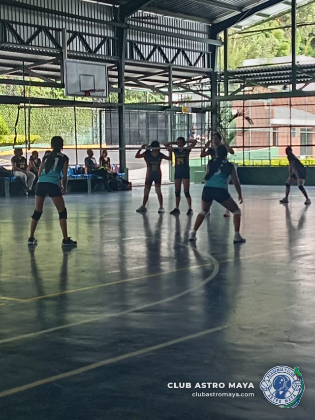 Equipo de voleibol del Club Astro Maya esperando el saque del rival en cancha techada